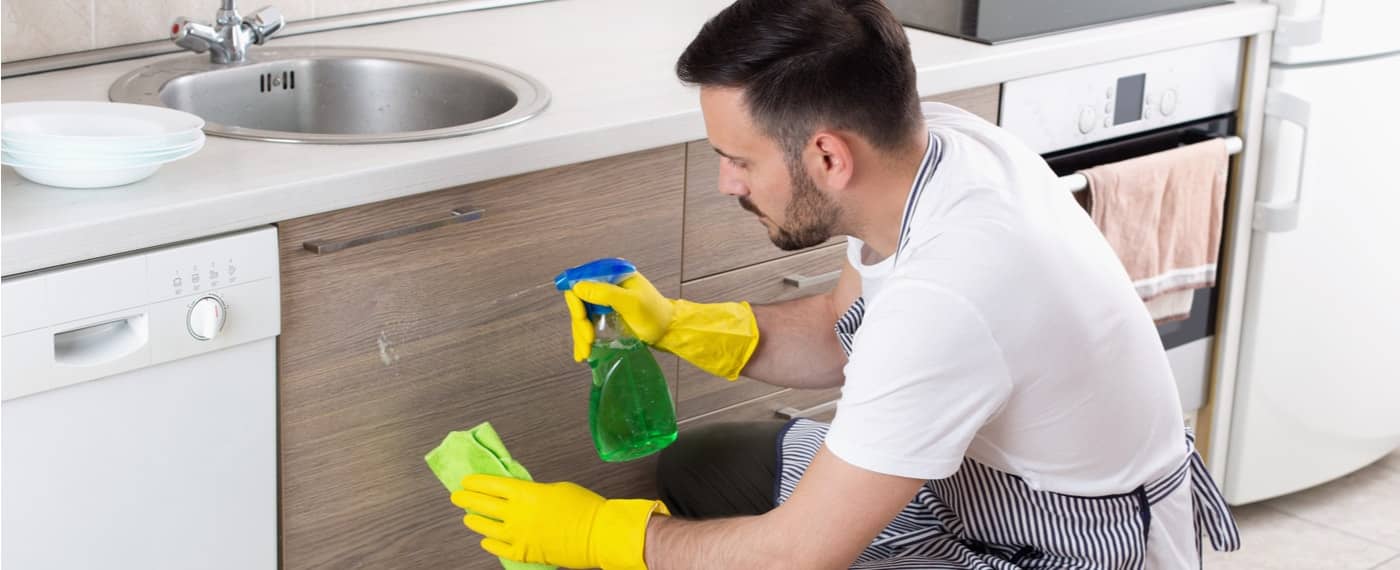 man using natural household cleaner in kitchen