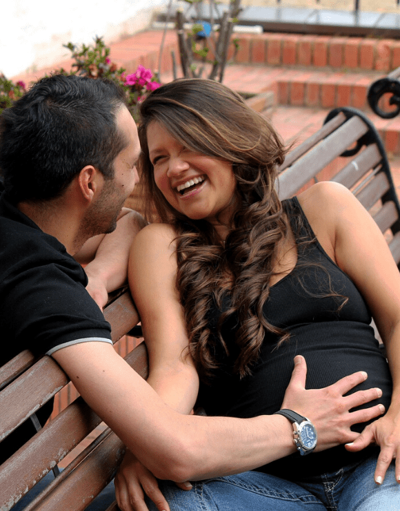 Father smiles with his hand on pregnant wife's stomach
