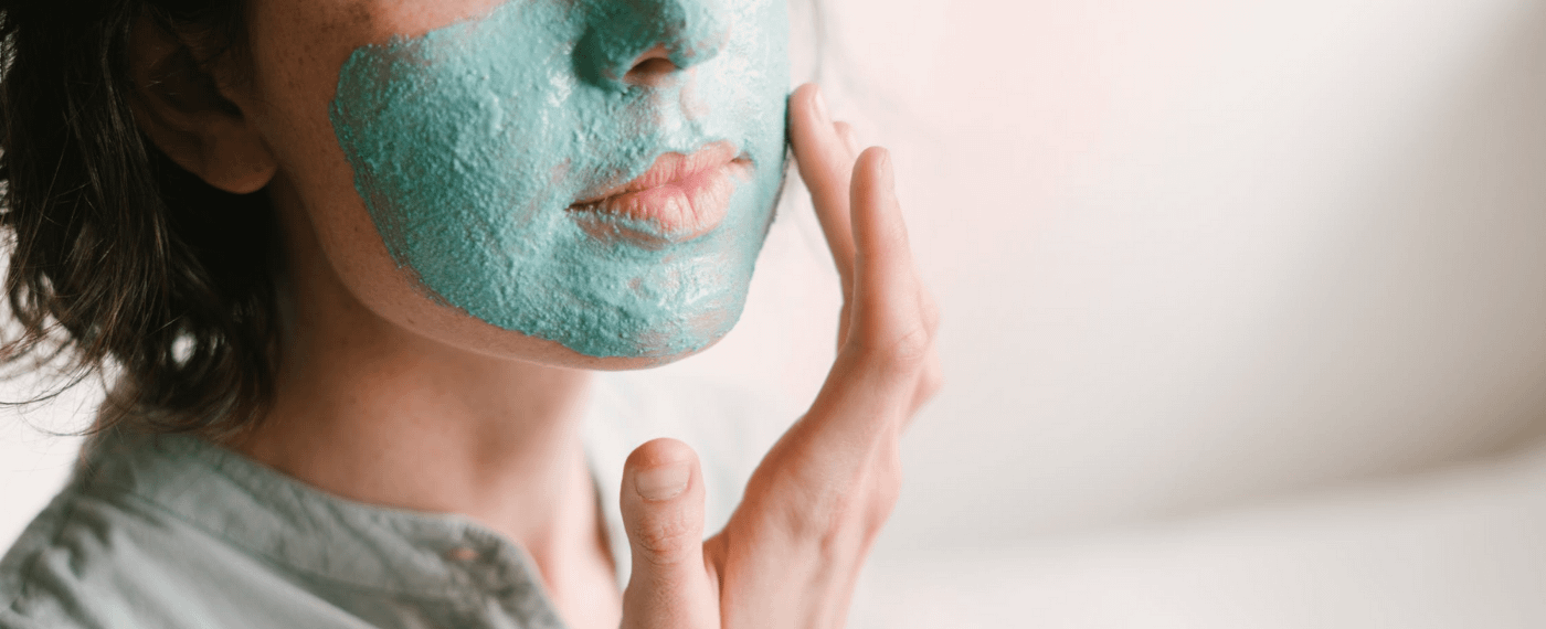 A woman applies a skincare mask as part of her self-care routine