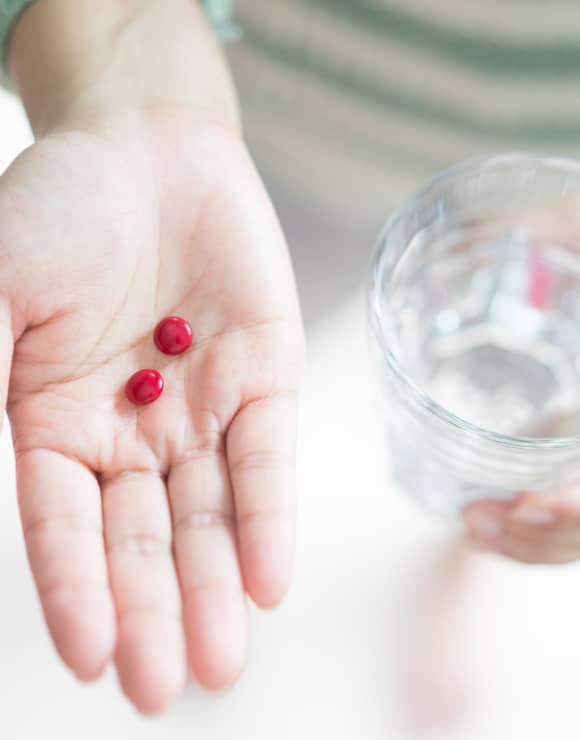 2 iron supplement pills held int he palm of a hand