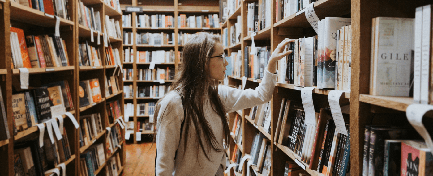 Female student browsing library for self development books