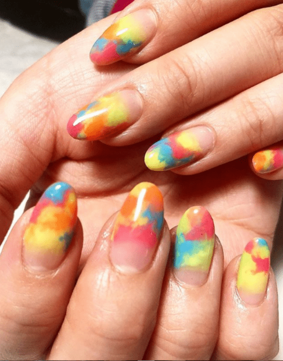 Up close shot of manicured nails with tie-dye nail polish