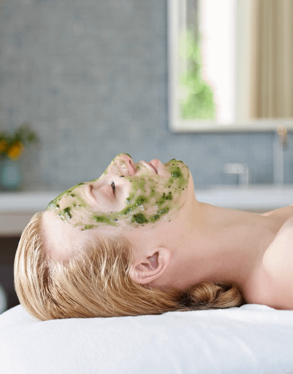 woman lies peacefully on massage table while wearing a CBD infused facial mask