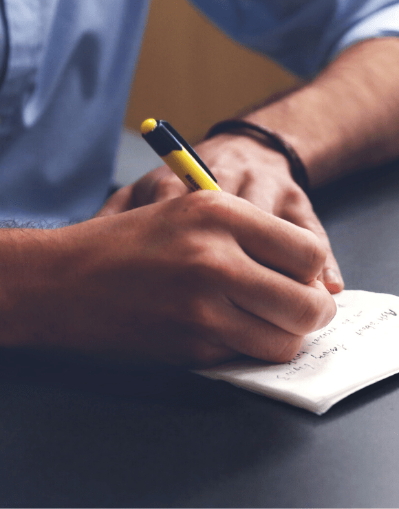 Man writing down self-care ideas